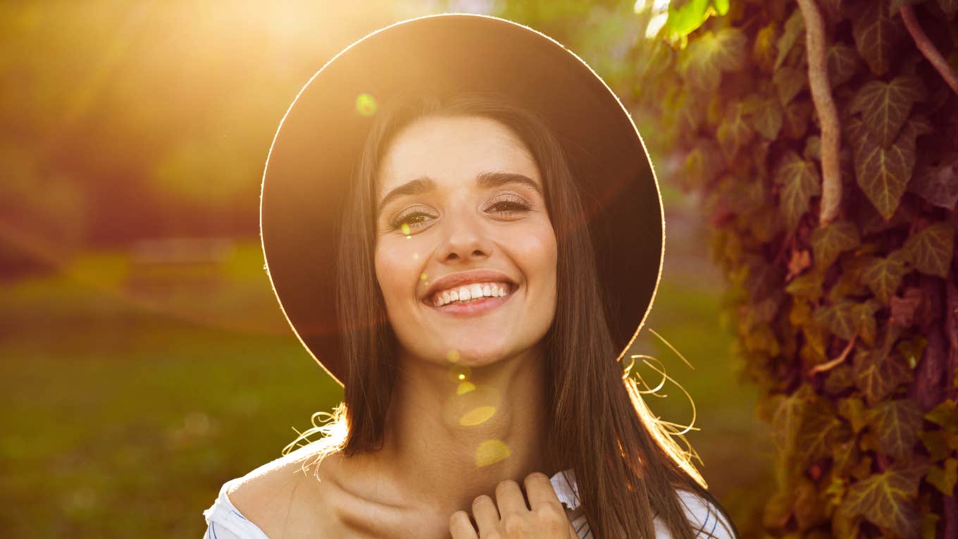 woman smiling, lit from behind, full of hte universe's wisdom