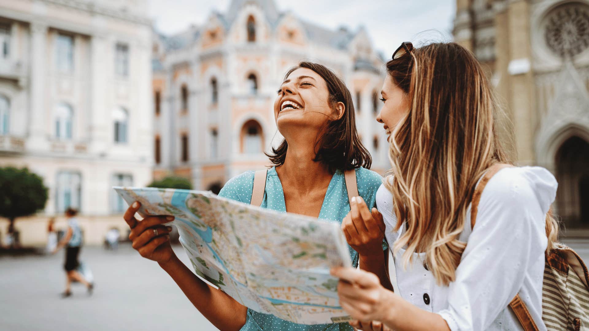 two woman holding map while traveling 