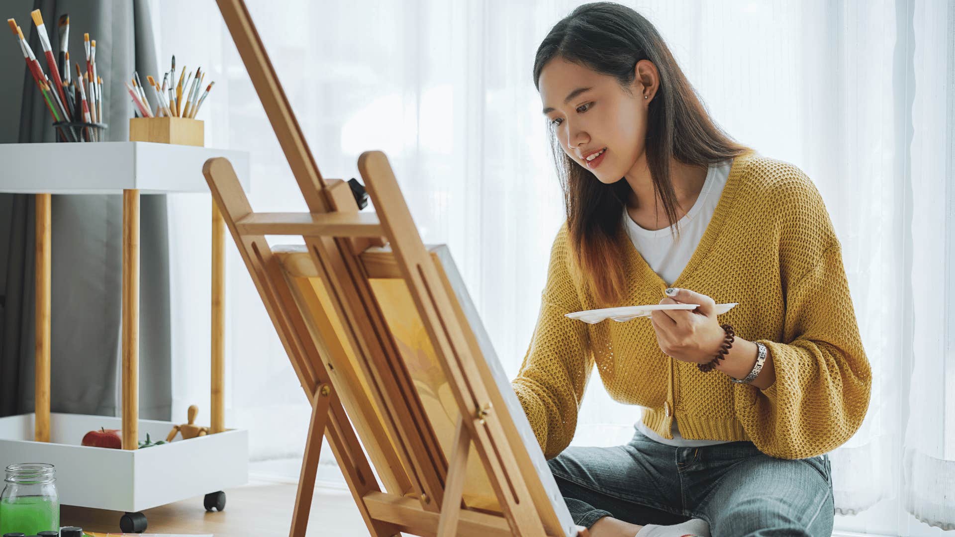 woman sitting down and painting