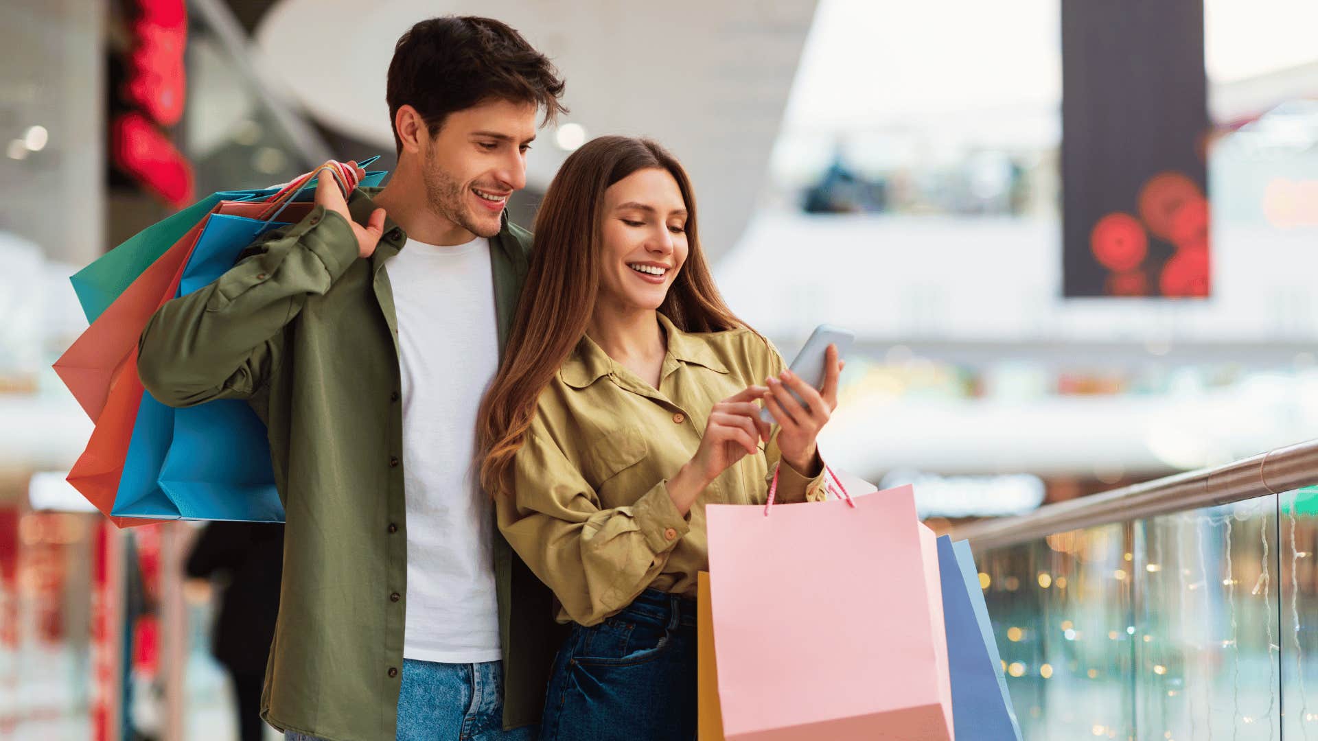 man and woman looking at phone while shopping 