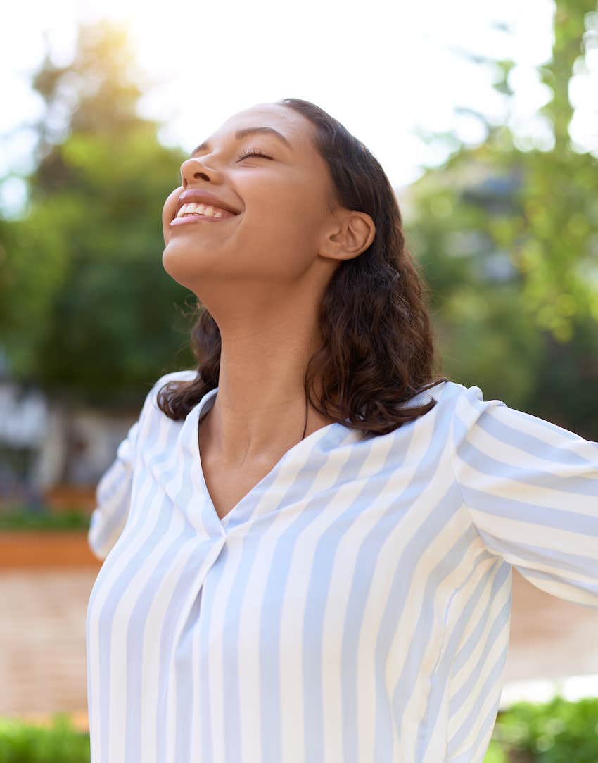 Arms outspread, she accepts joy as a golden rule in her life