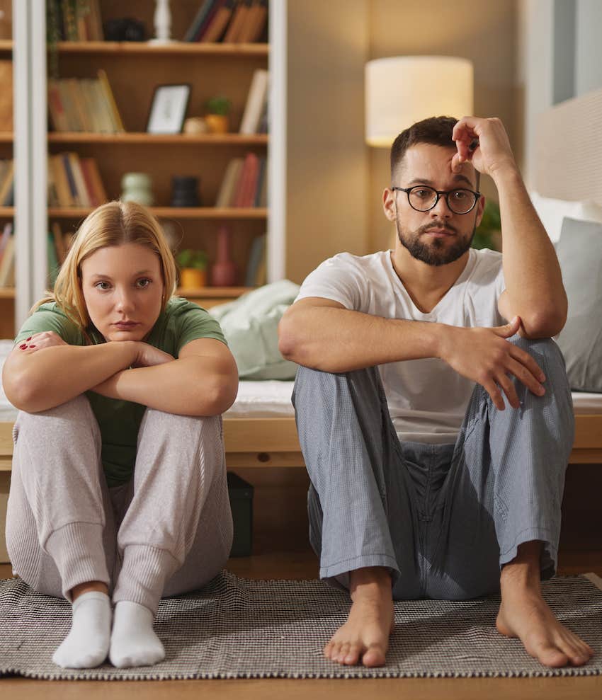 Side by side, sitting on the floor, a displeased couple wonders if they can survive infidelity