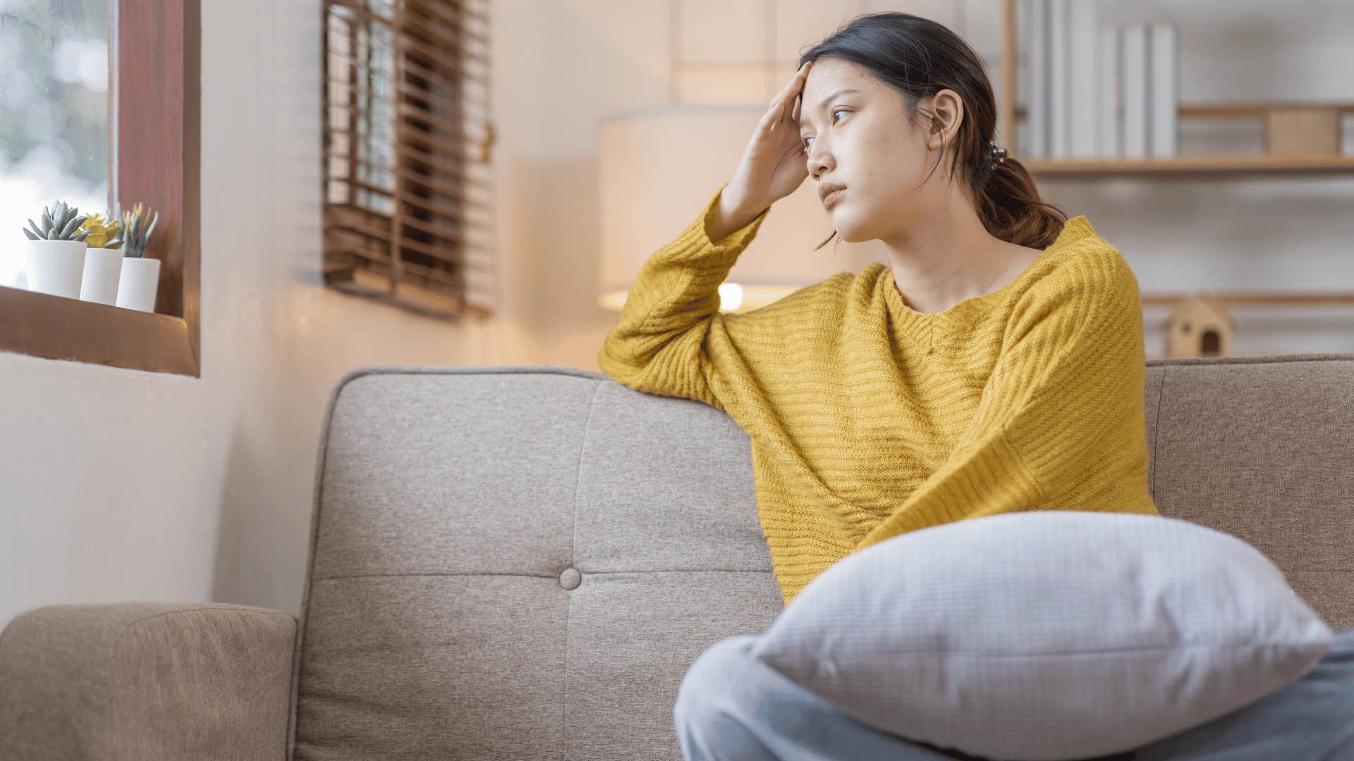 worried woman sitting on couch