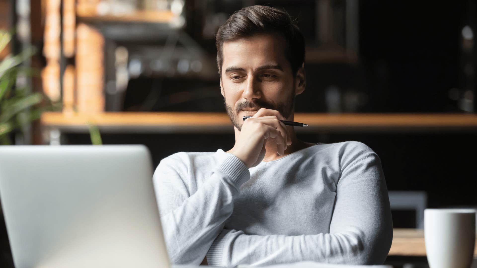 man thinking deeply while staring at laptop