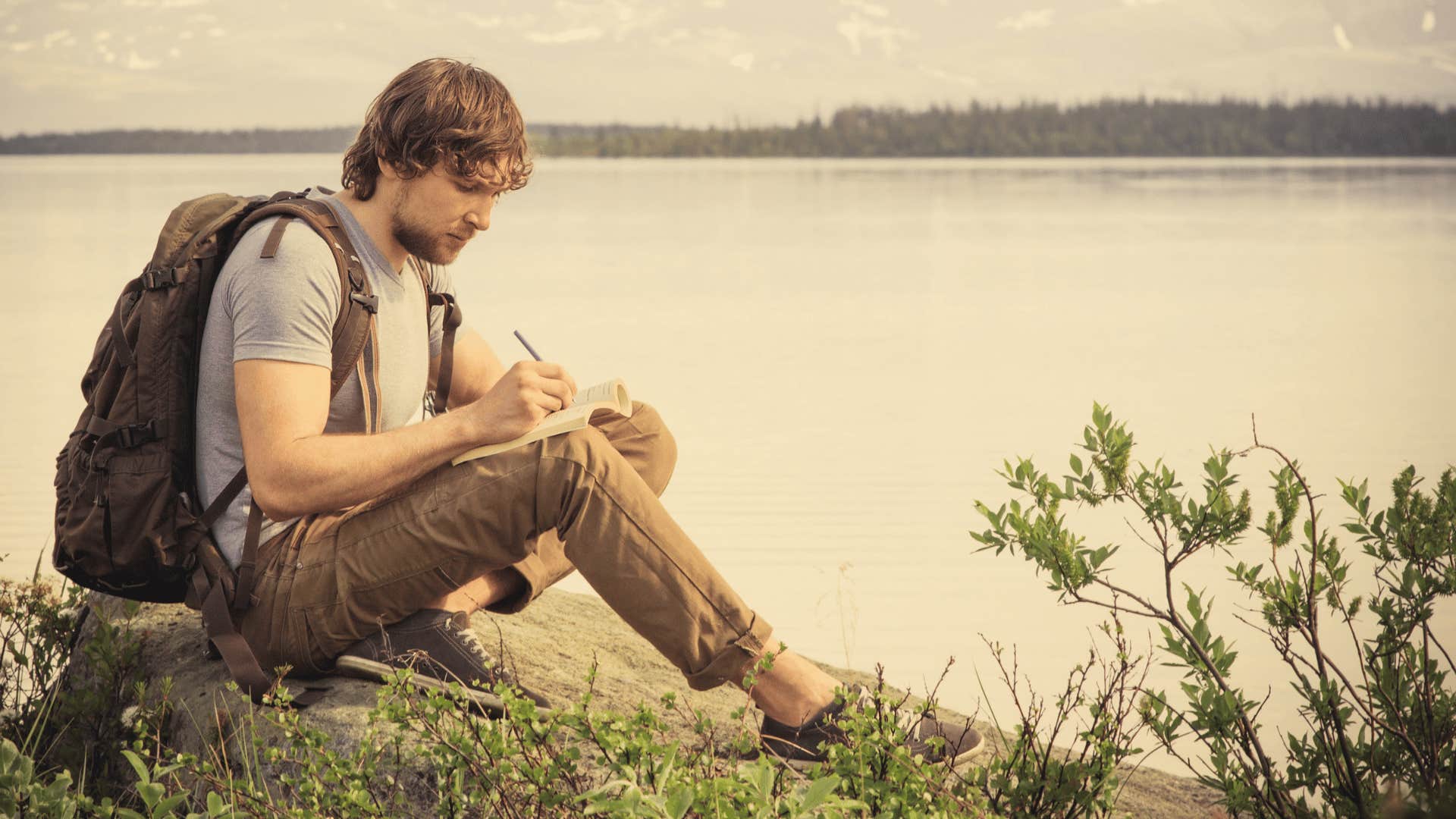 man deep in thought writing in journal 