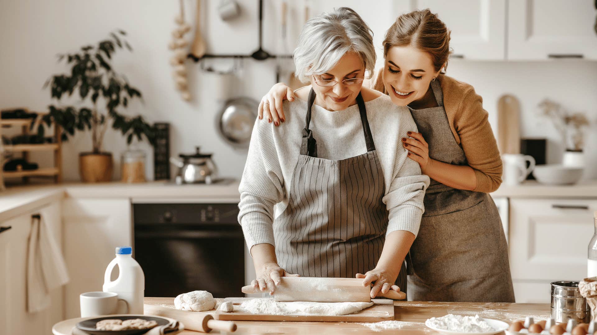 woman hugging older woman while baking