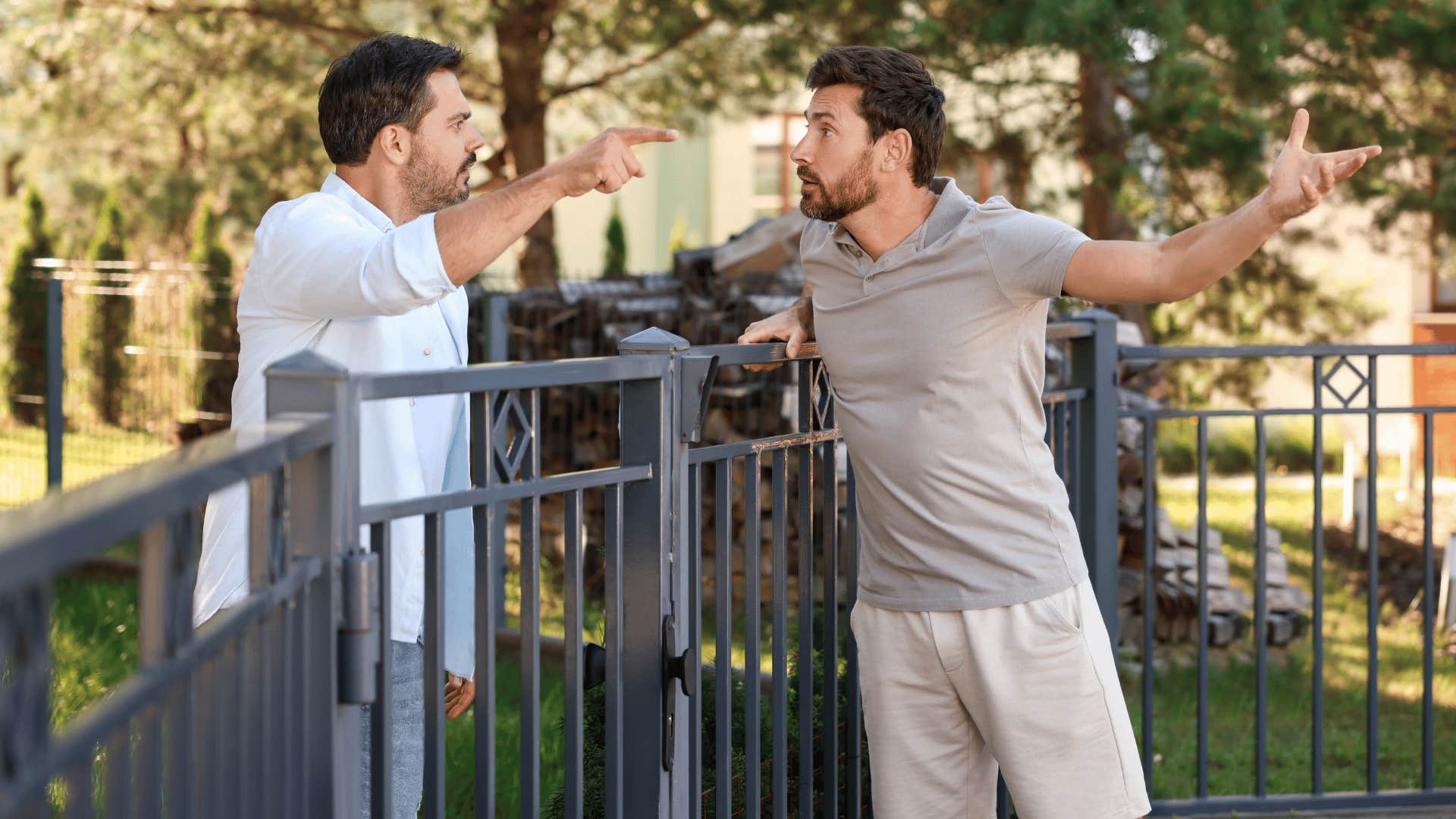 two men arguing over a fence 