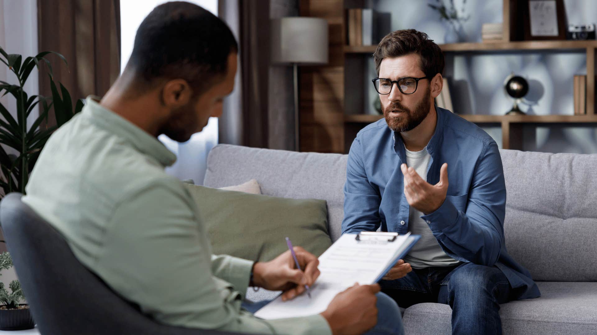 therapist writing down notes while patient stares at therapist