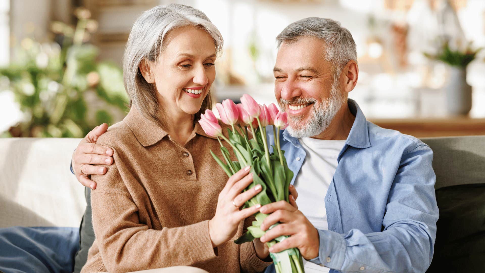 older man handing older woman flowers 