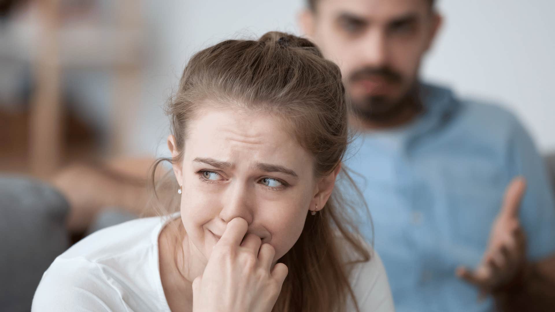 woman crying with man in background