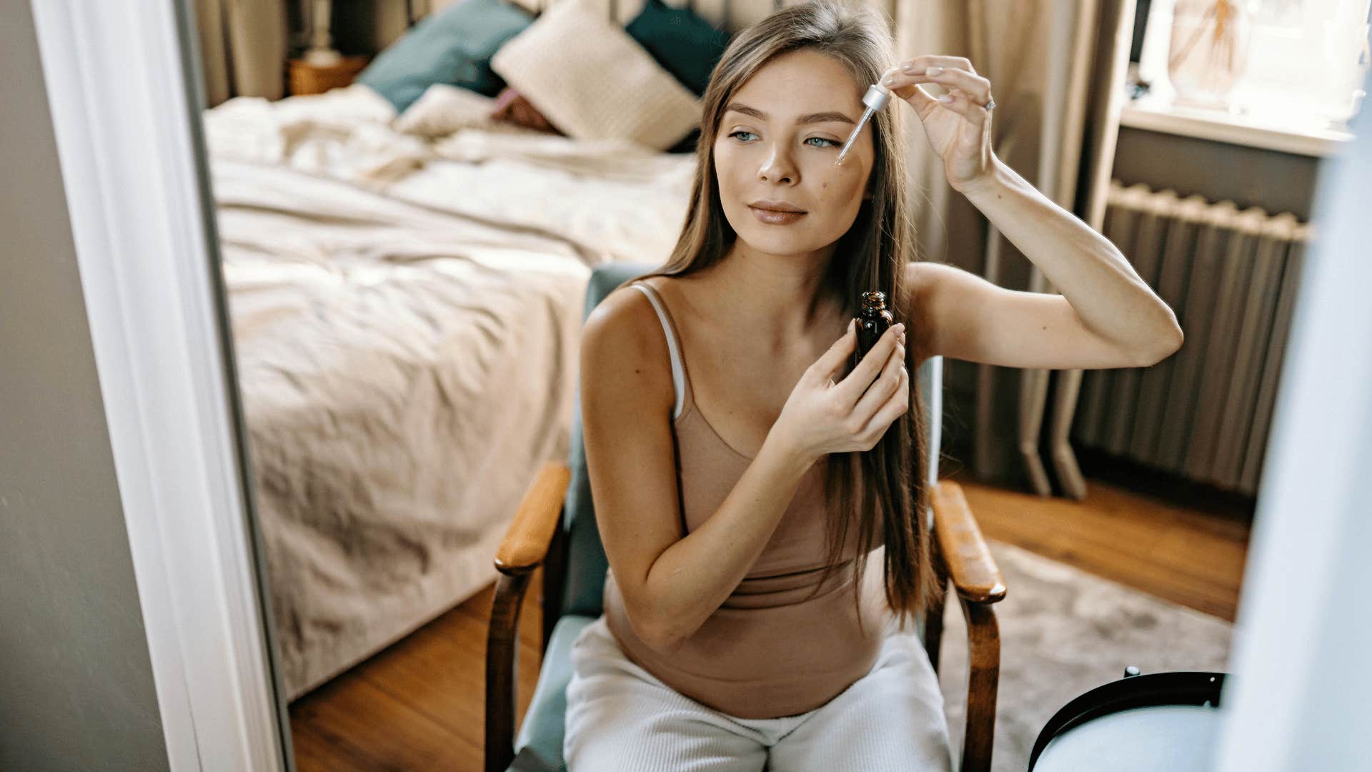 woman doing face care in front of mirror