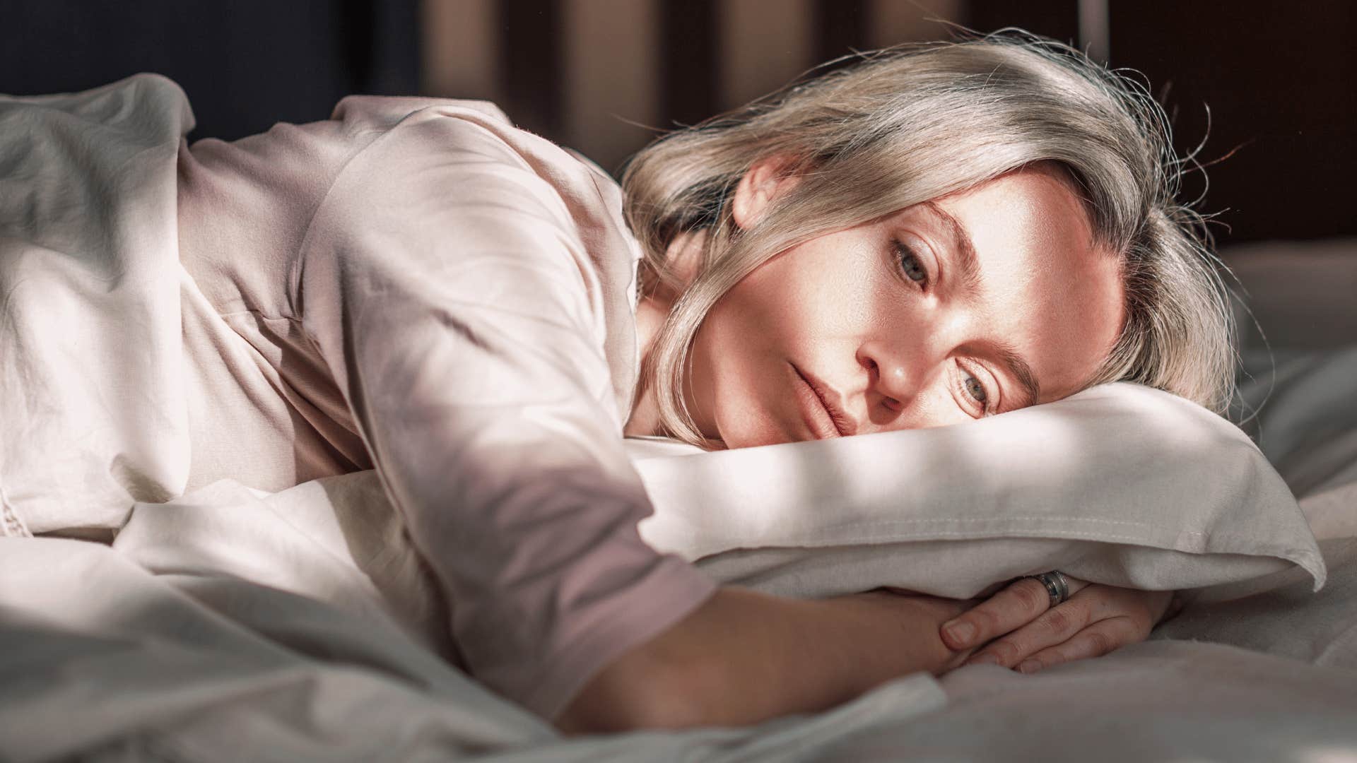 woman laying down looking upset