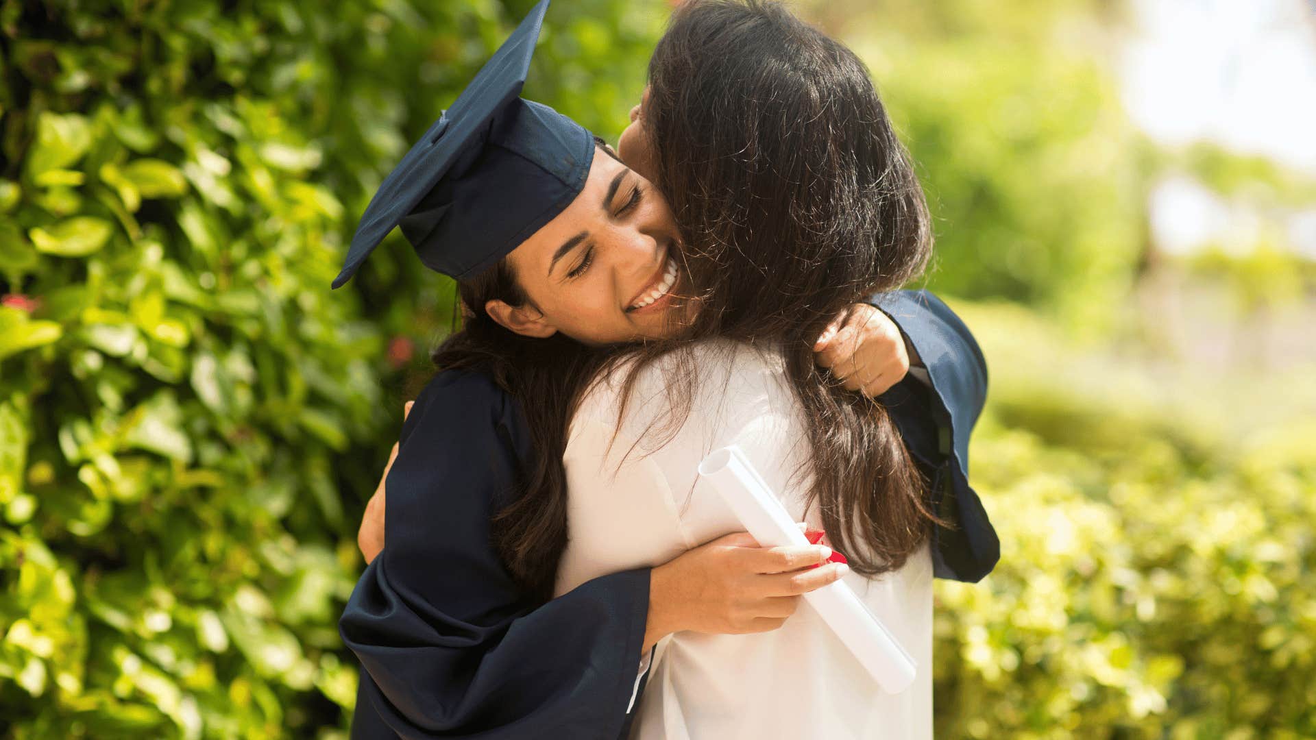 woman hugging daughter who recently graduated