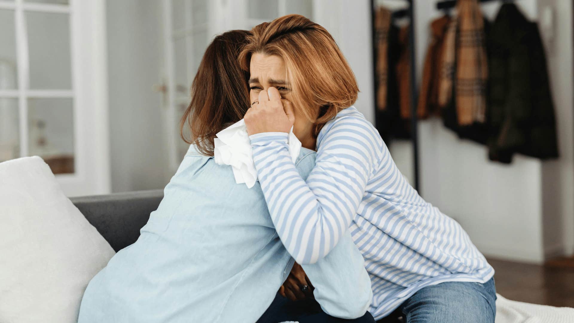 two woman hugging and crying