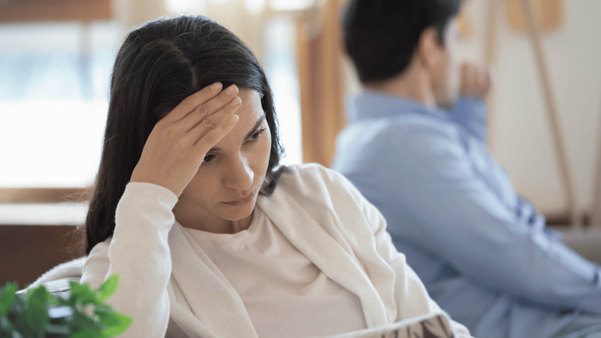 woman looking away from partner sitting on couch