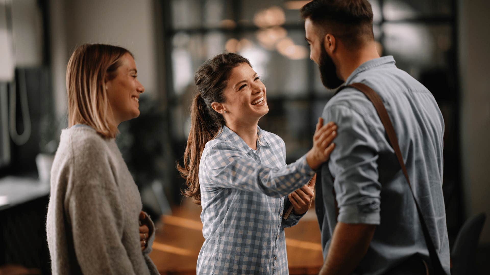 woman patting man on shoulder while smiling