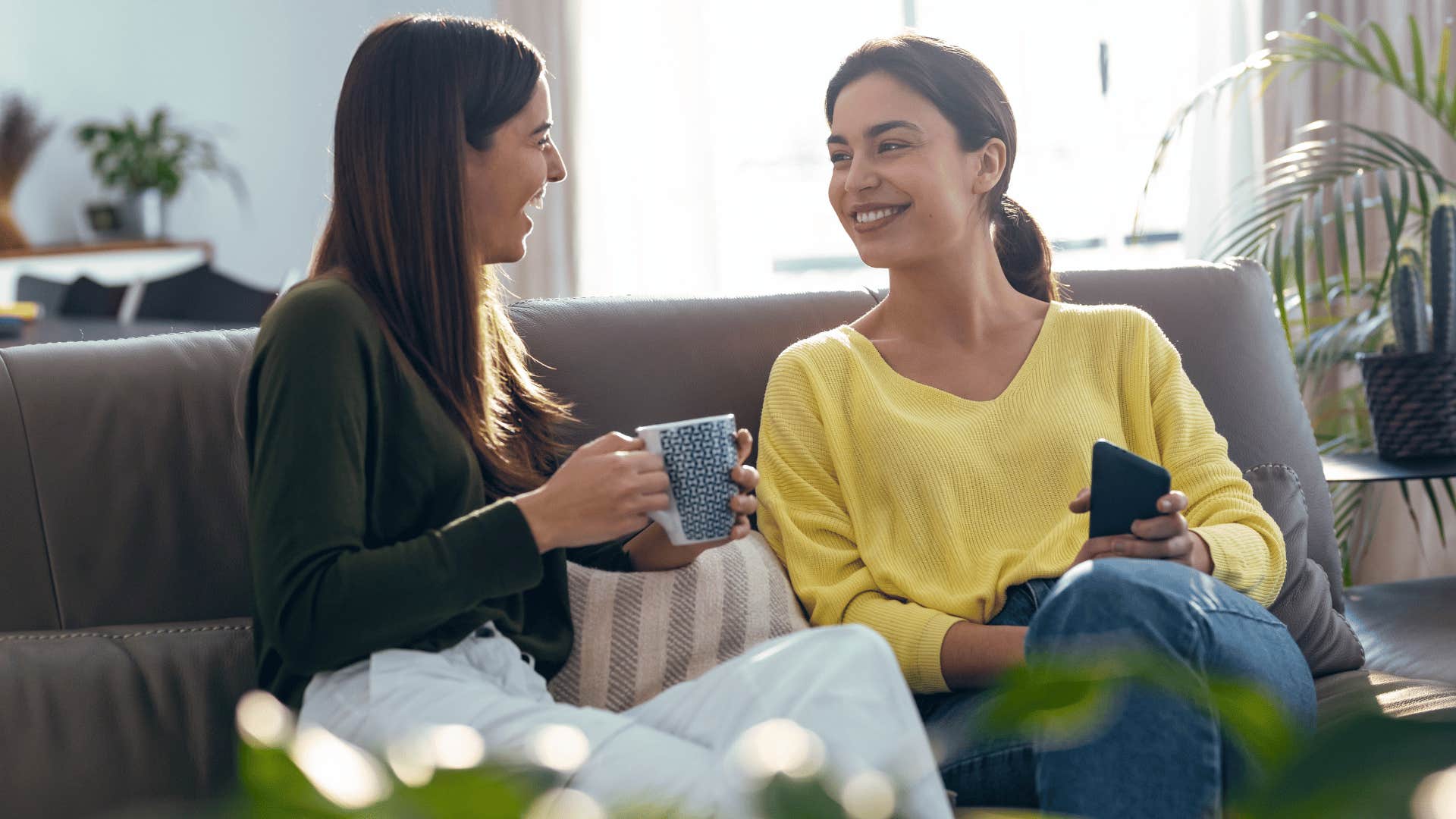 two women chatting on couch