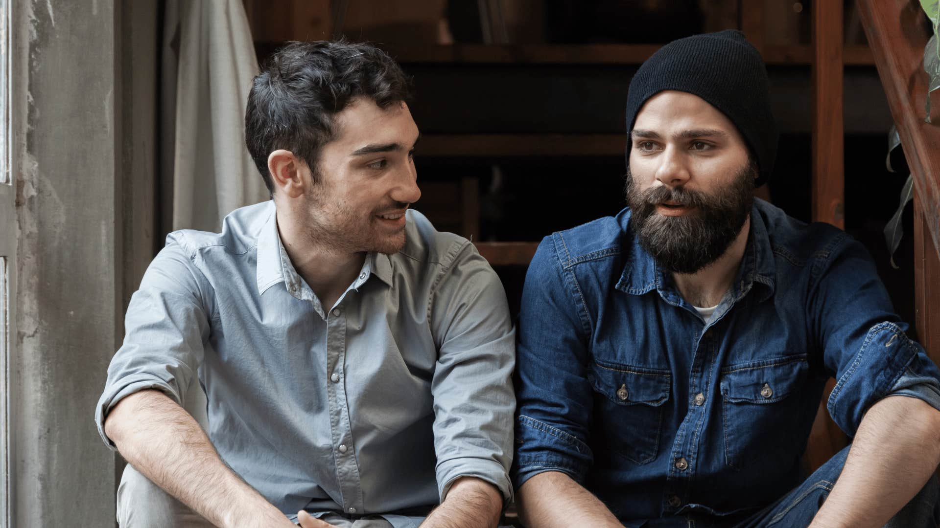 two men sitting on stairs talking