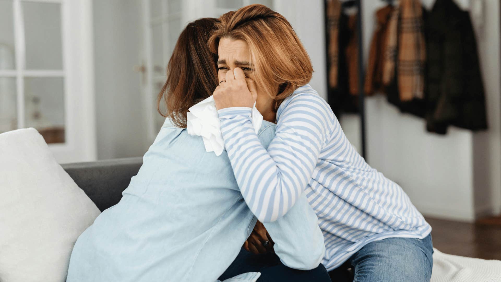 woman hugging other woman while crying 