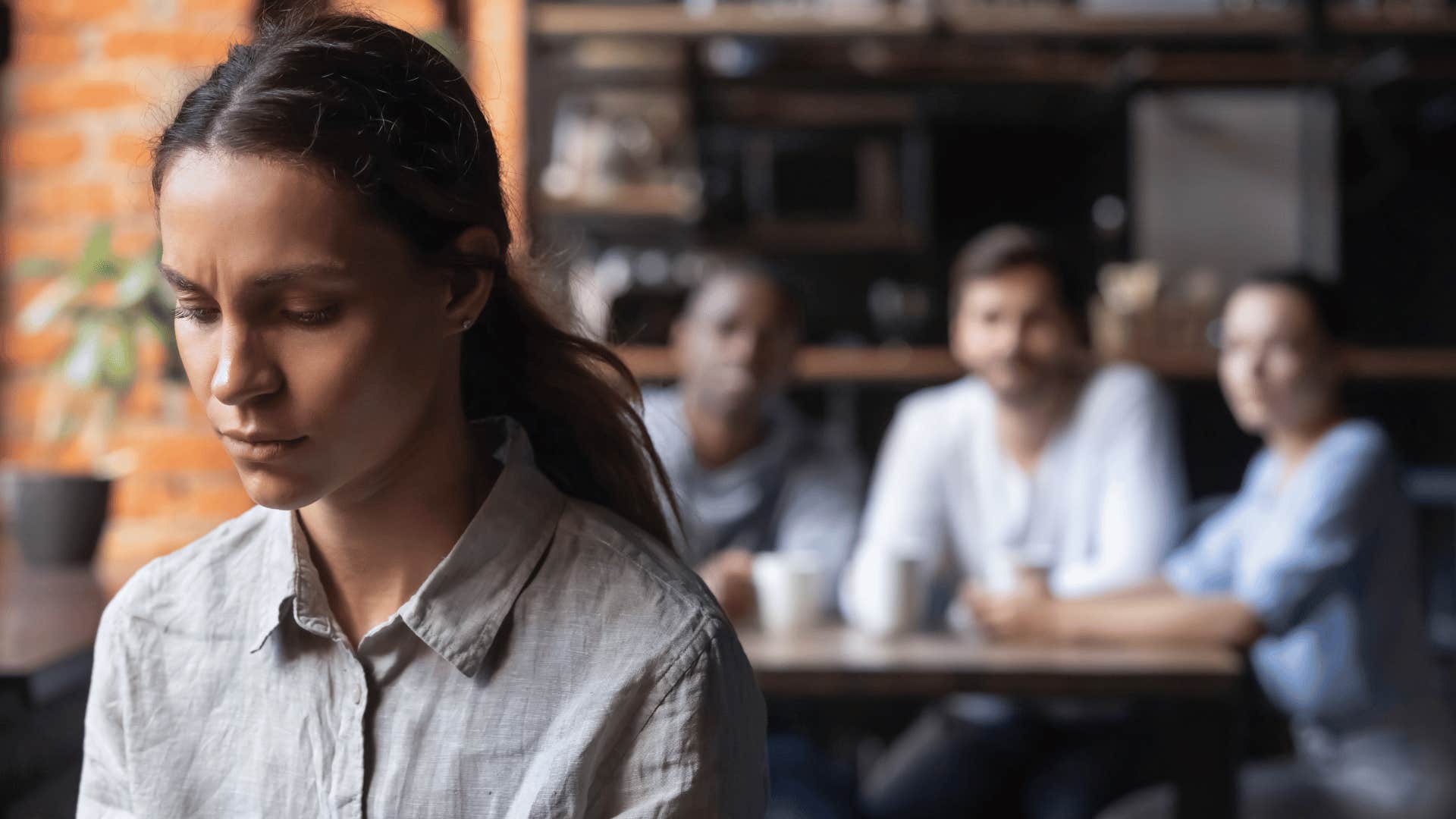 woman outcasted while friends stare at her