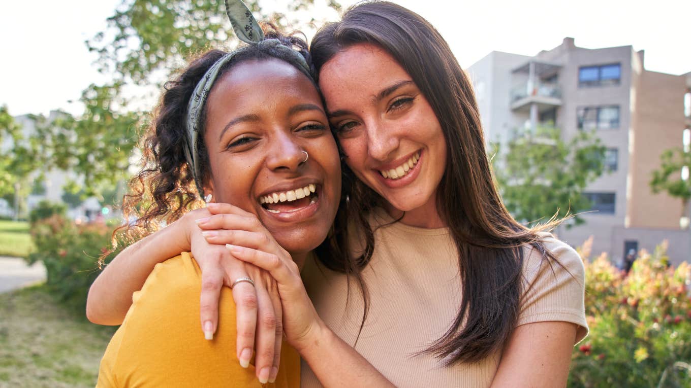 two friends smiling and hugging