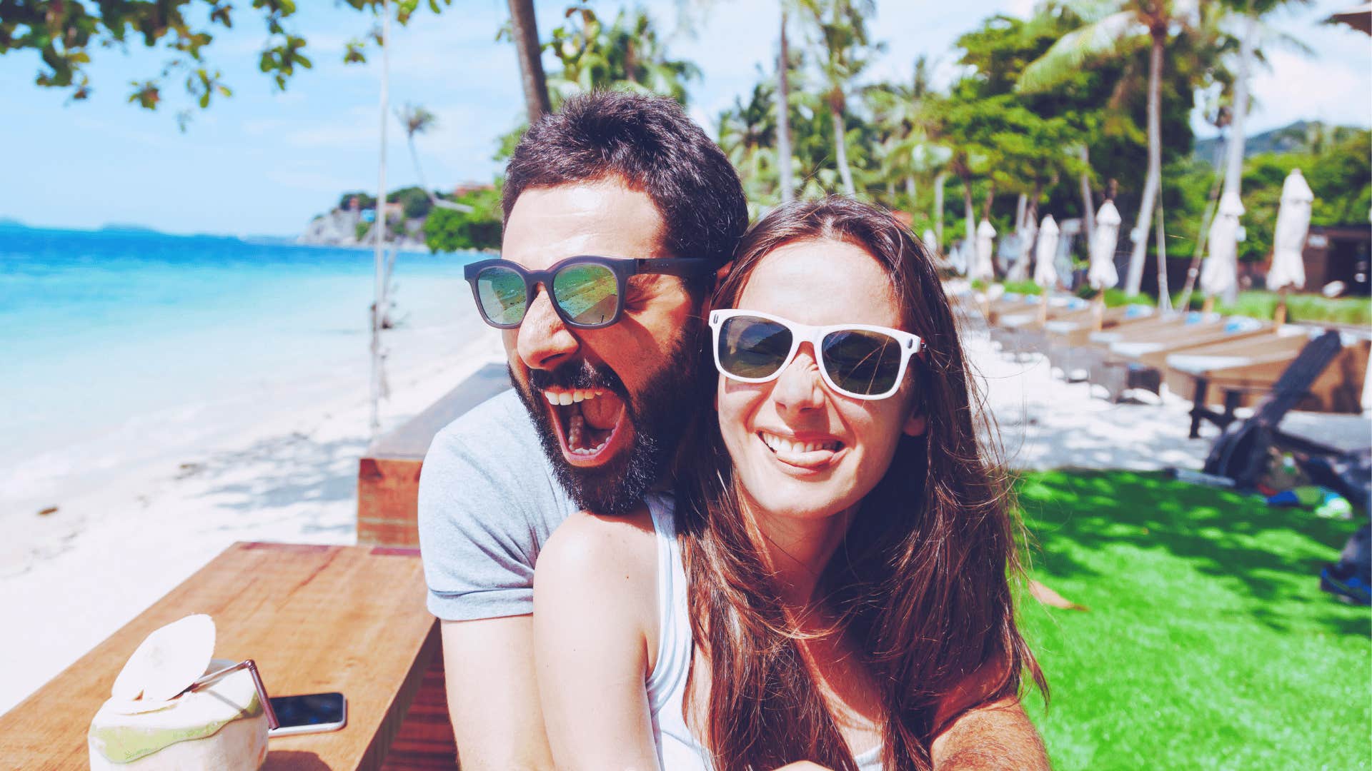 Couple in sunglasses, laughing happily together