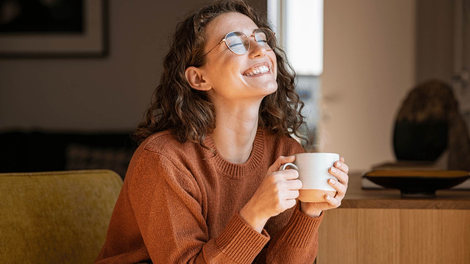 woman enjoying hot drink while smiling