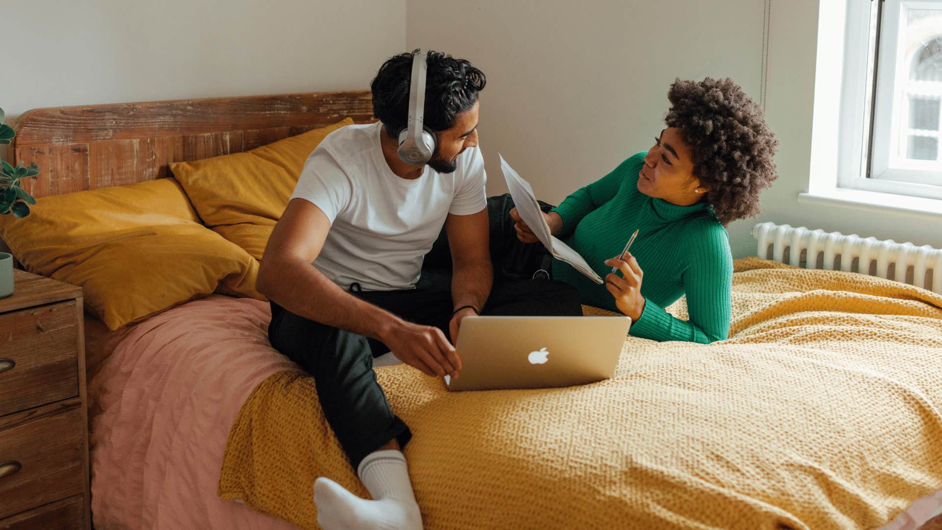 friends sitting on bed trying to understand each other