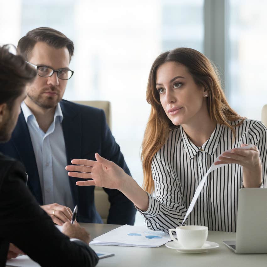 Employer presenting a resignation letter to a worker during meeting. 