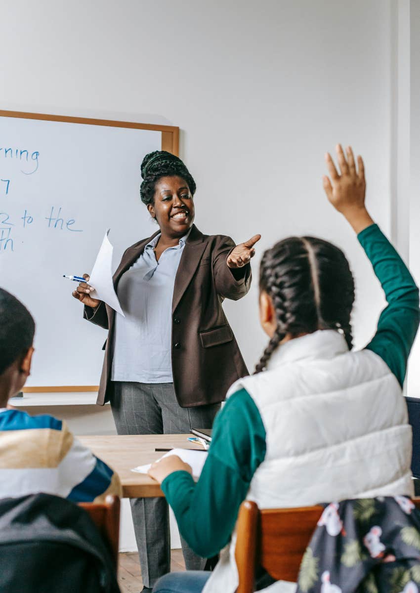 teacher calling on student who raised her hand