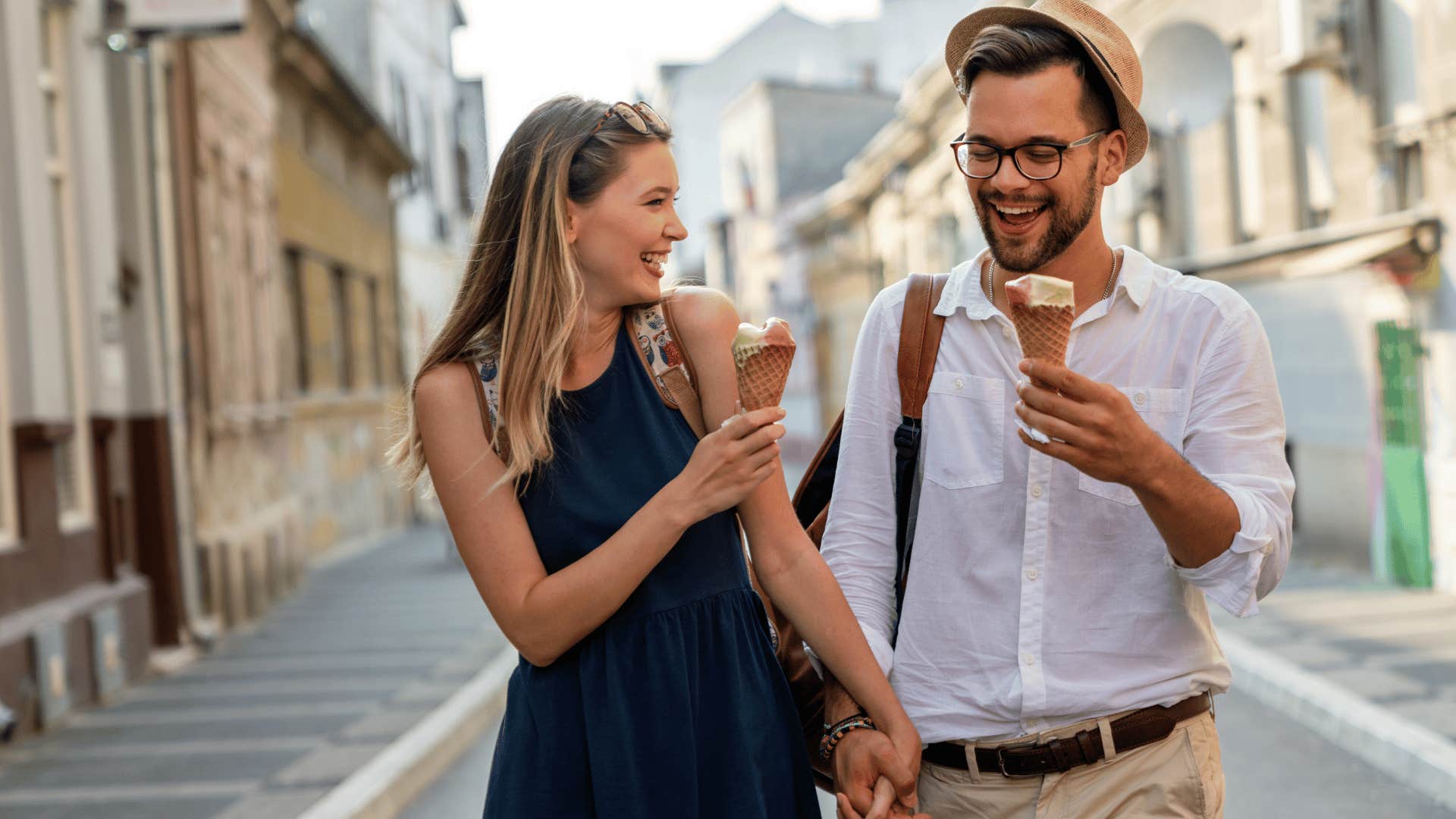 man and woman holding hands and eating icecream 