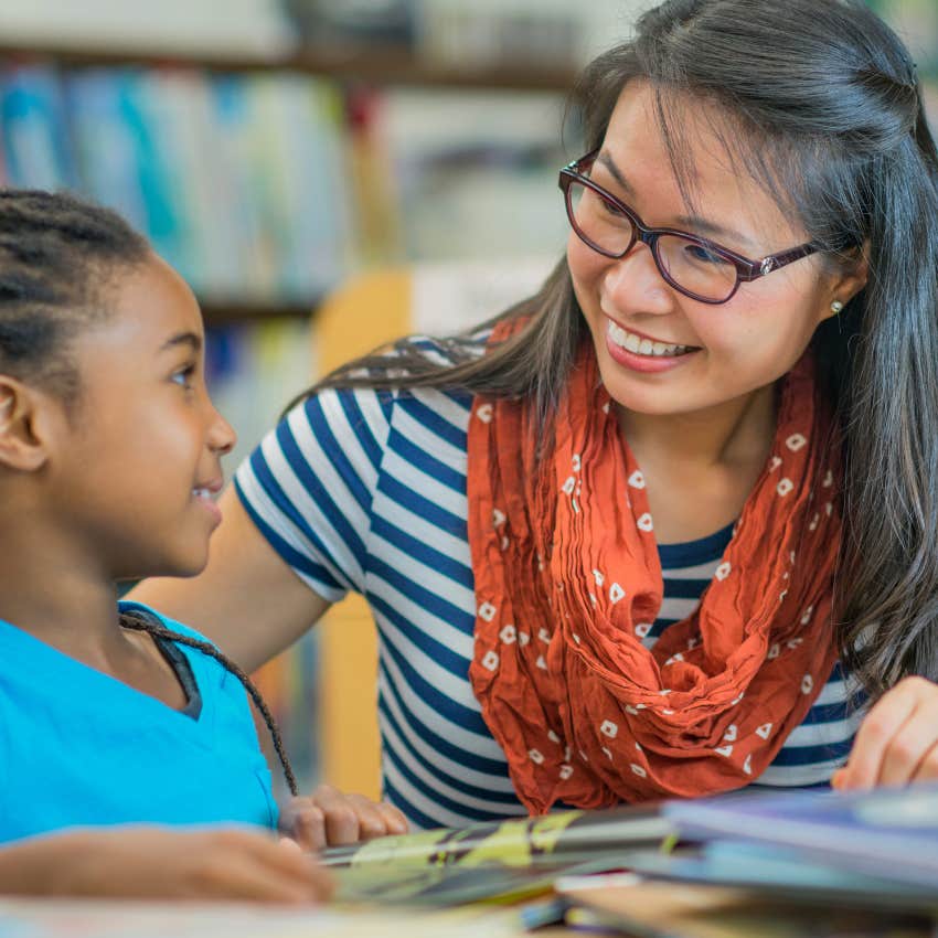 Teacher with speech impediment reading with a student. 