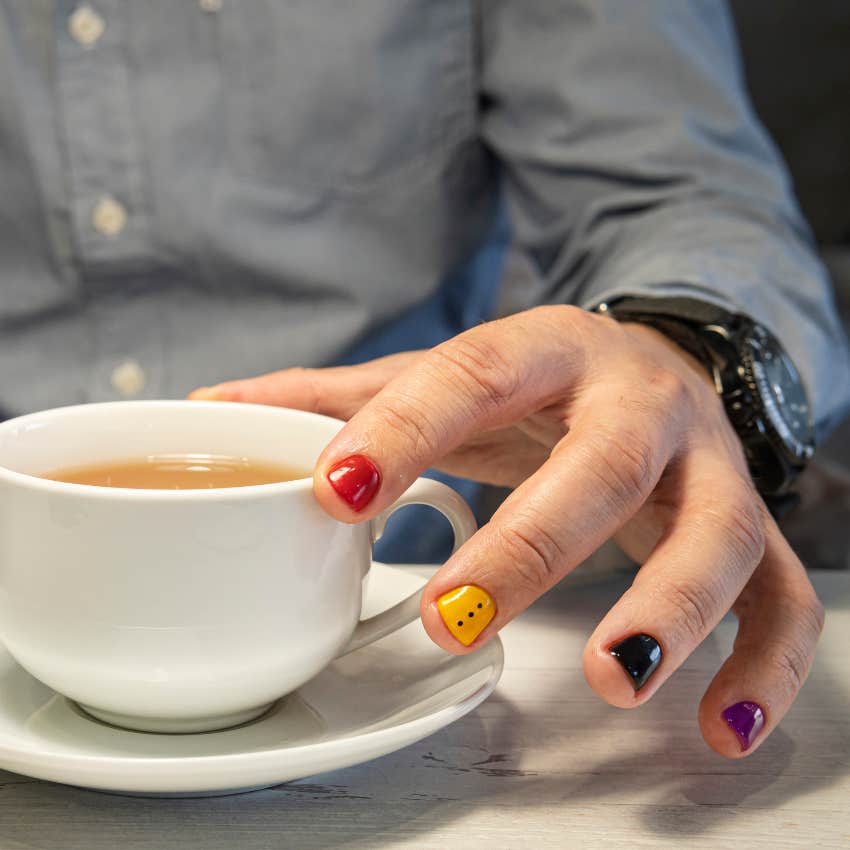 Boy with painted nails sitting next to an authorized customer