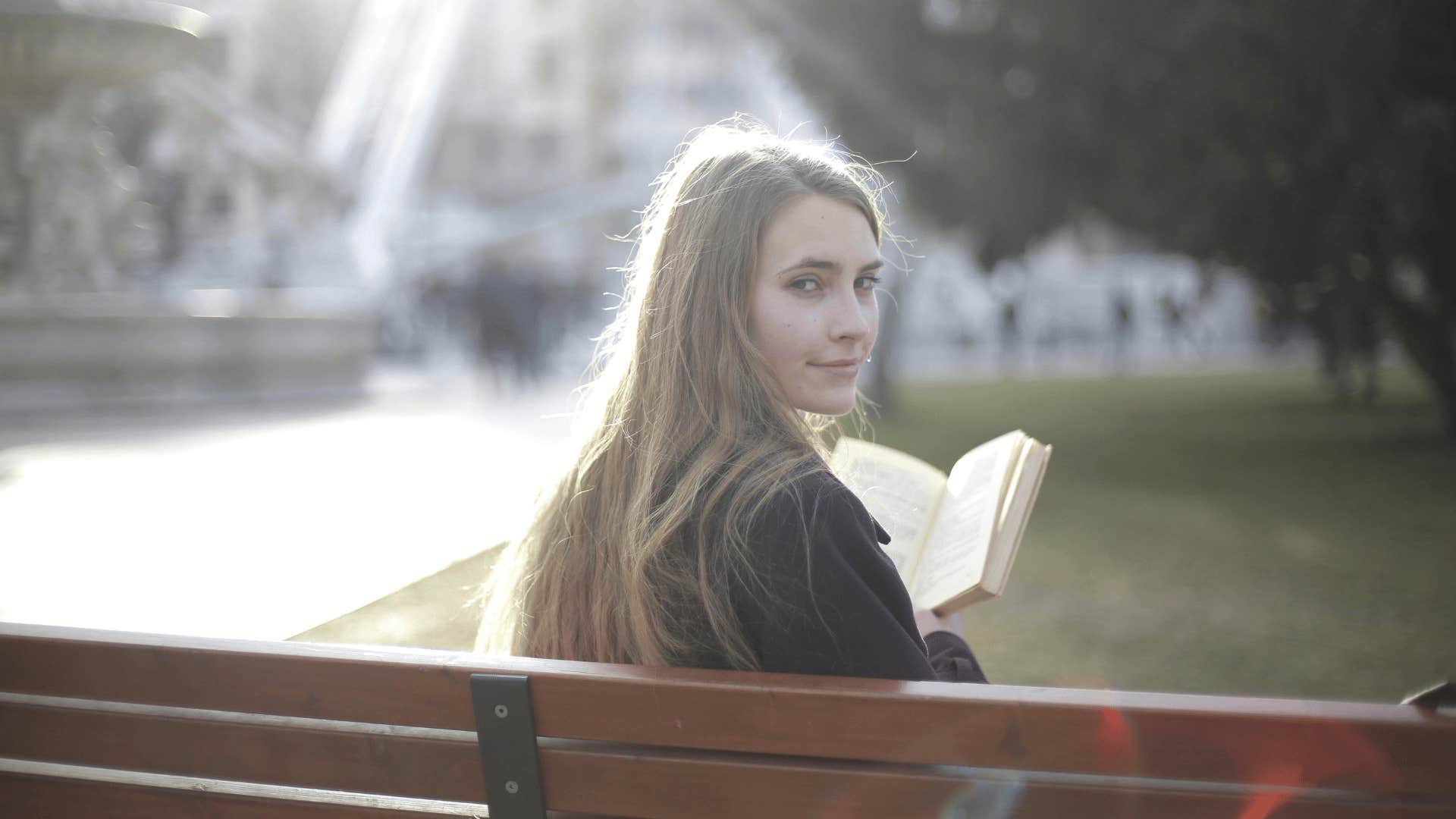 woman reading on a park bench 