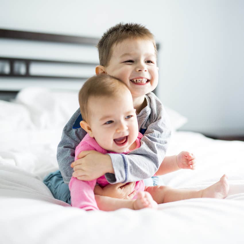 Toddler cuddling baby