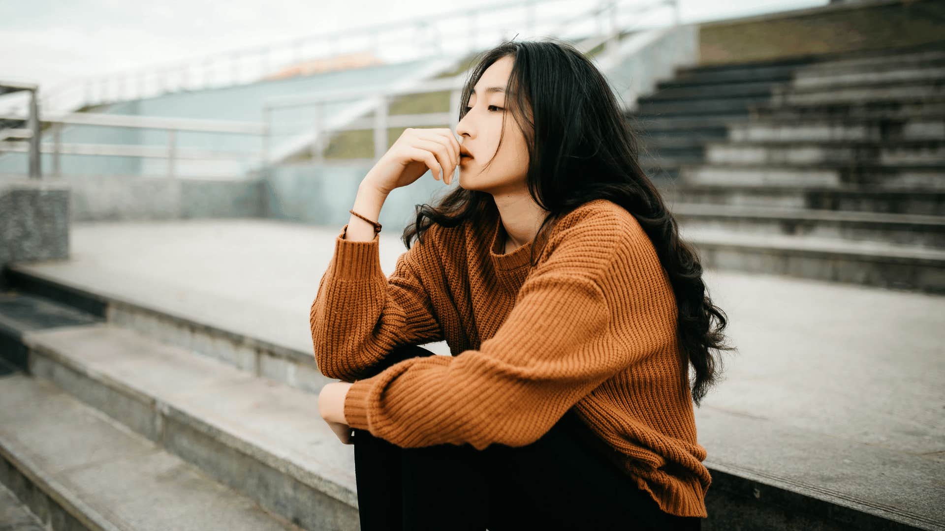 woman sitting on cement stairs