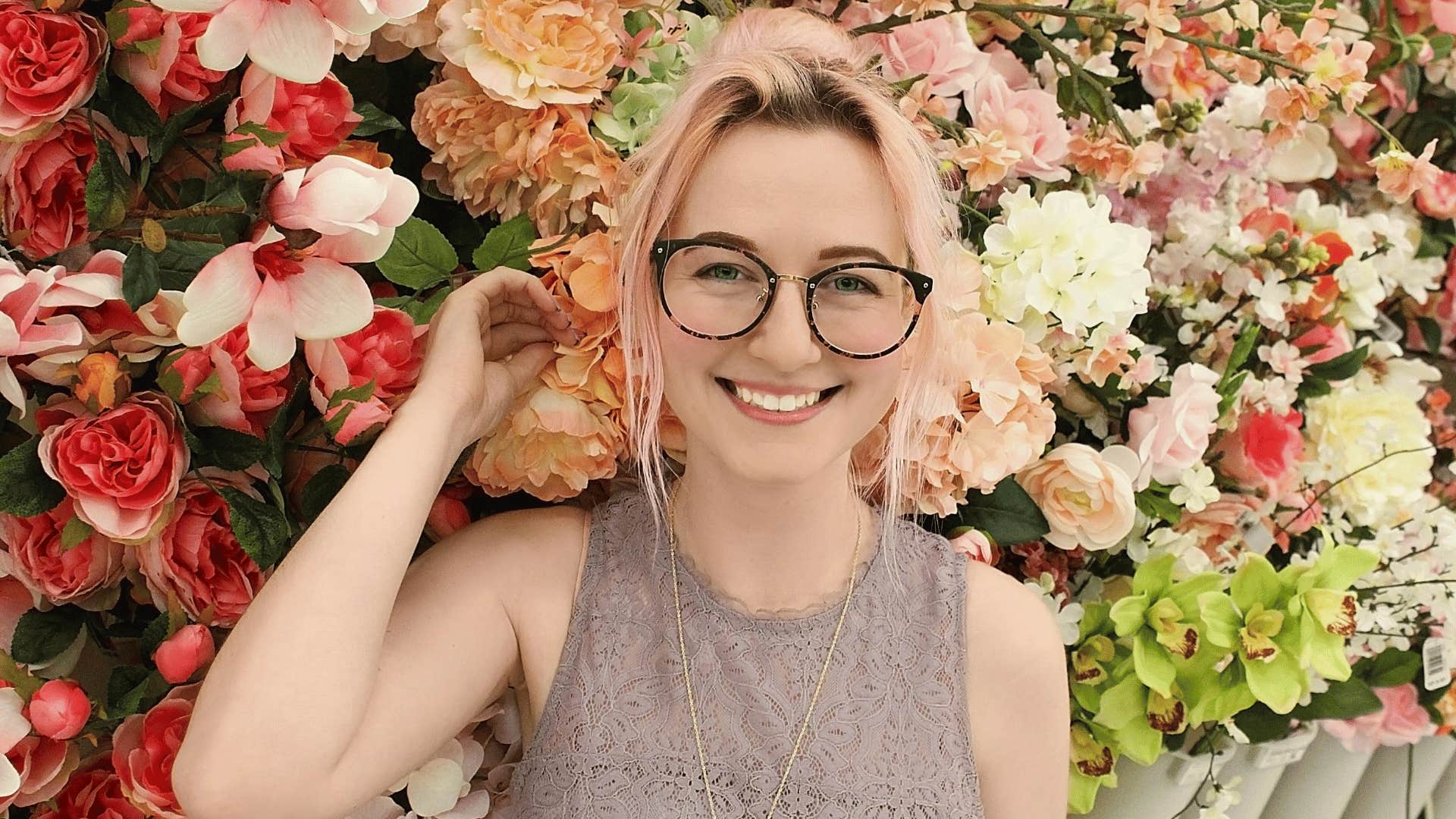 smiling woman in front of flowers