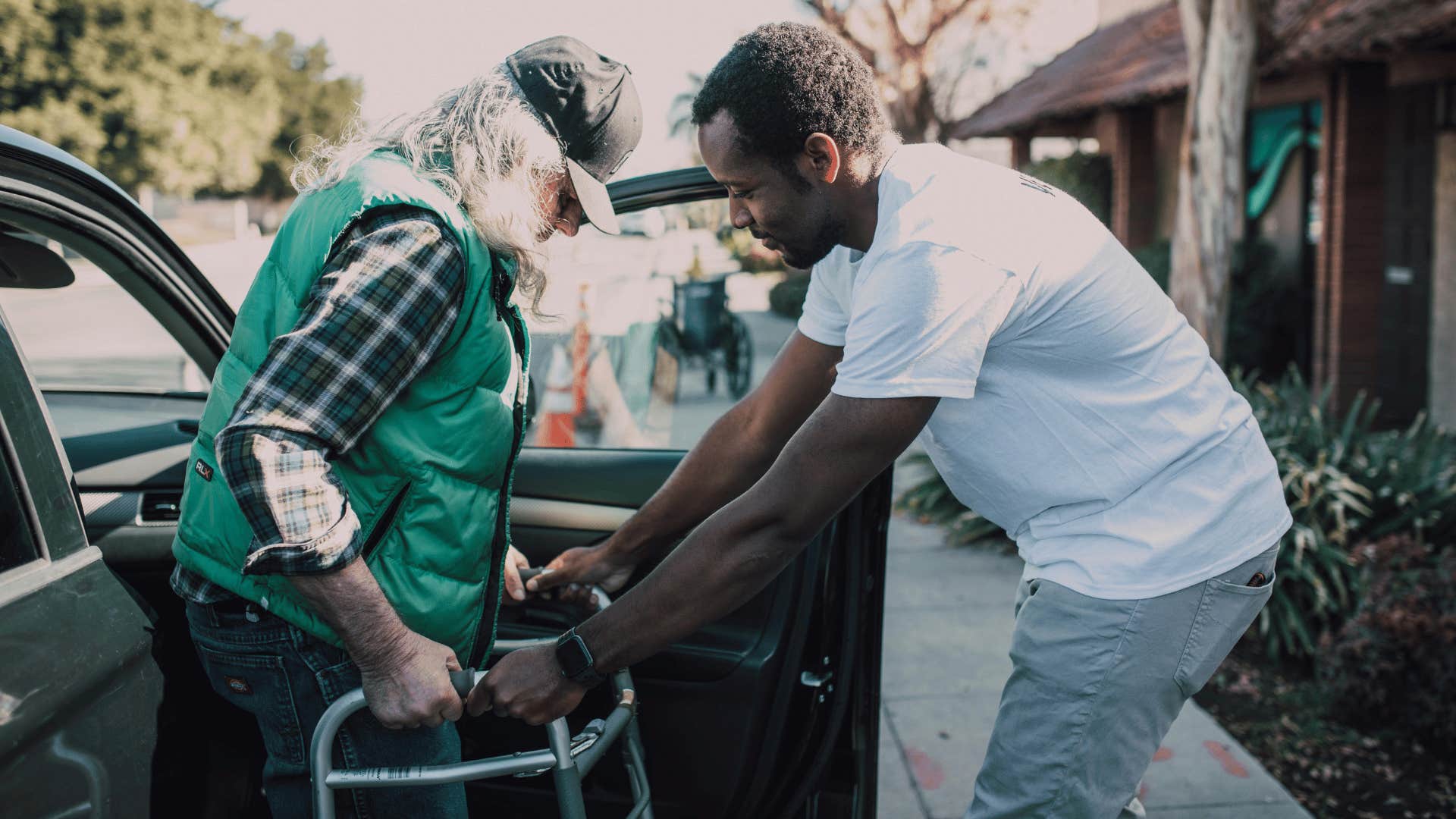 man helping other man get out of car