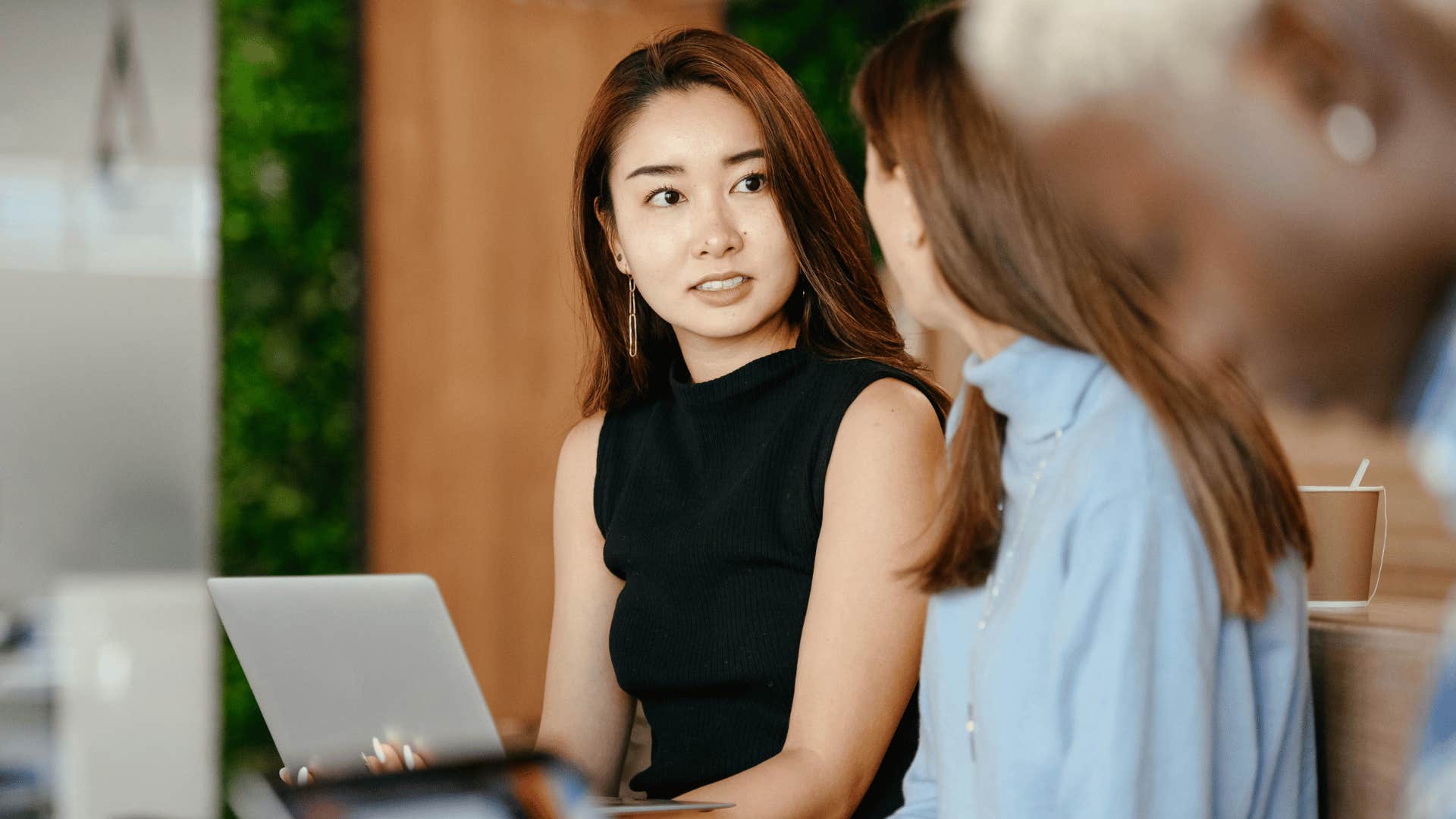 woman talking to other woman looking uncomfortable 