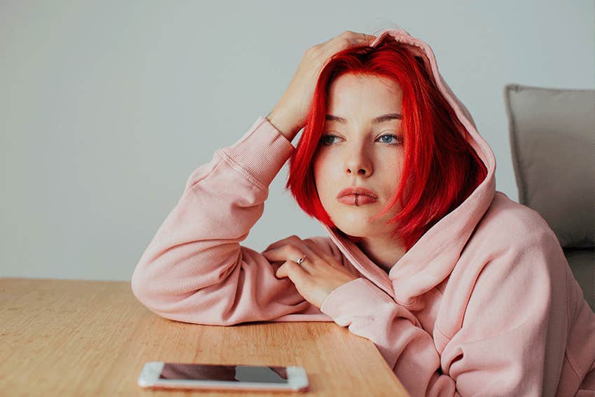 Portrait of a woman holding head on desk