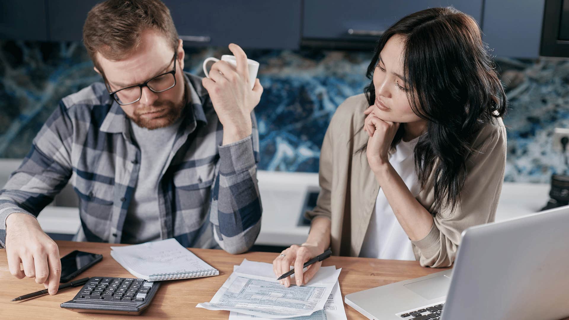 man and woman looking at bills