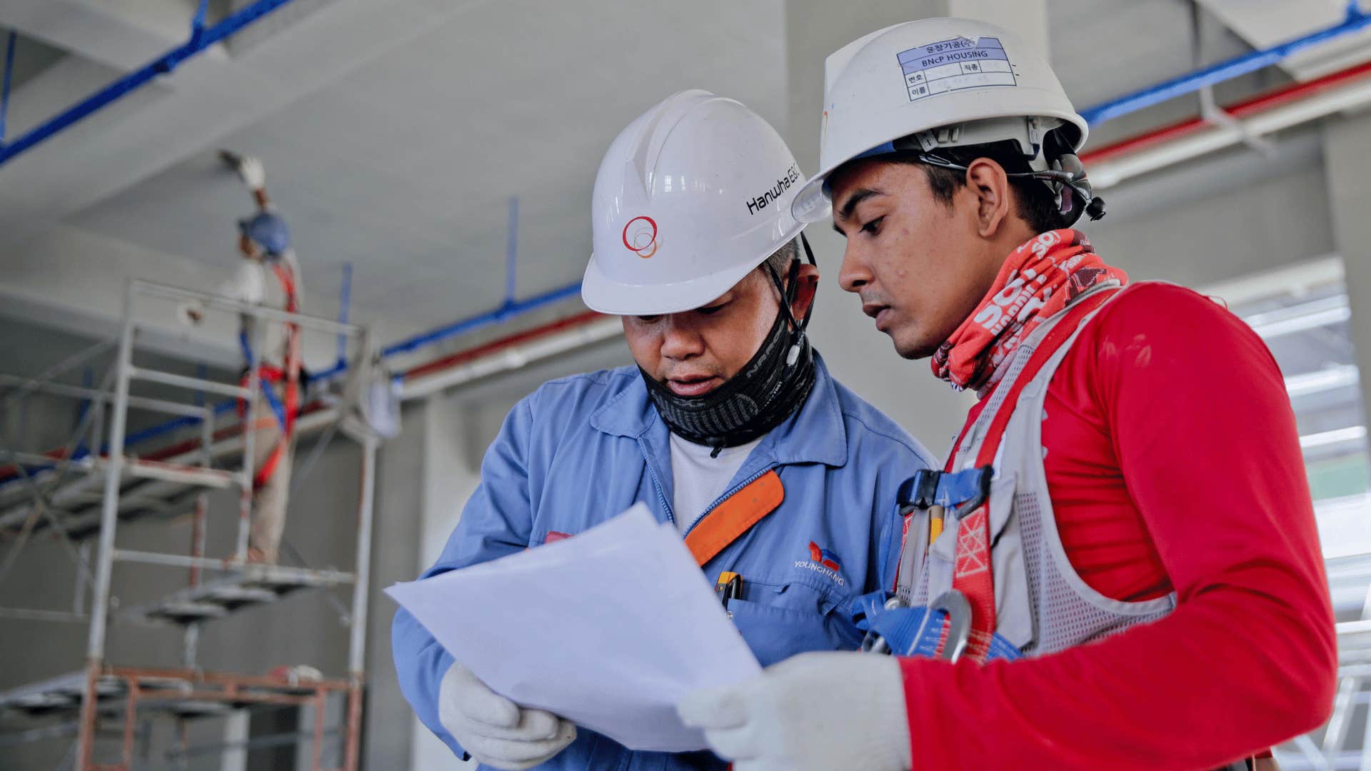 two men looking at sheet while working