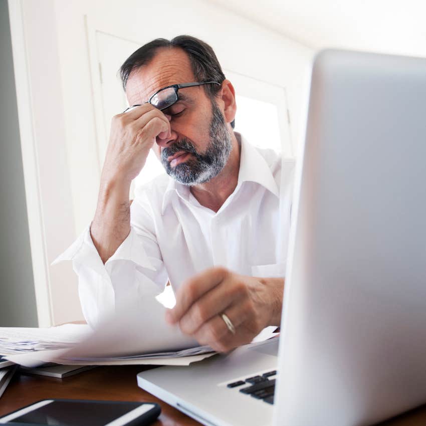 Father looking frustrating staring at inheritance paperwork. 