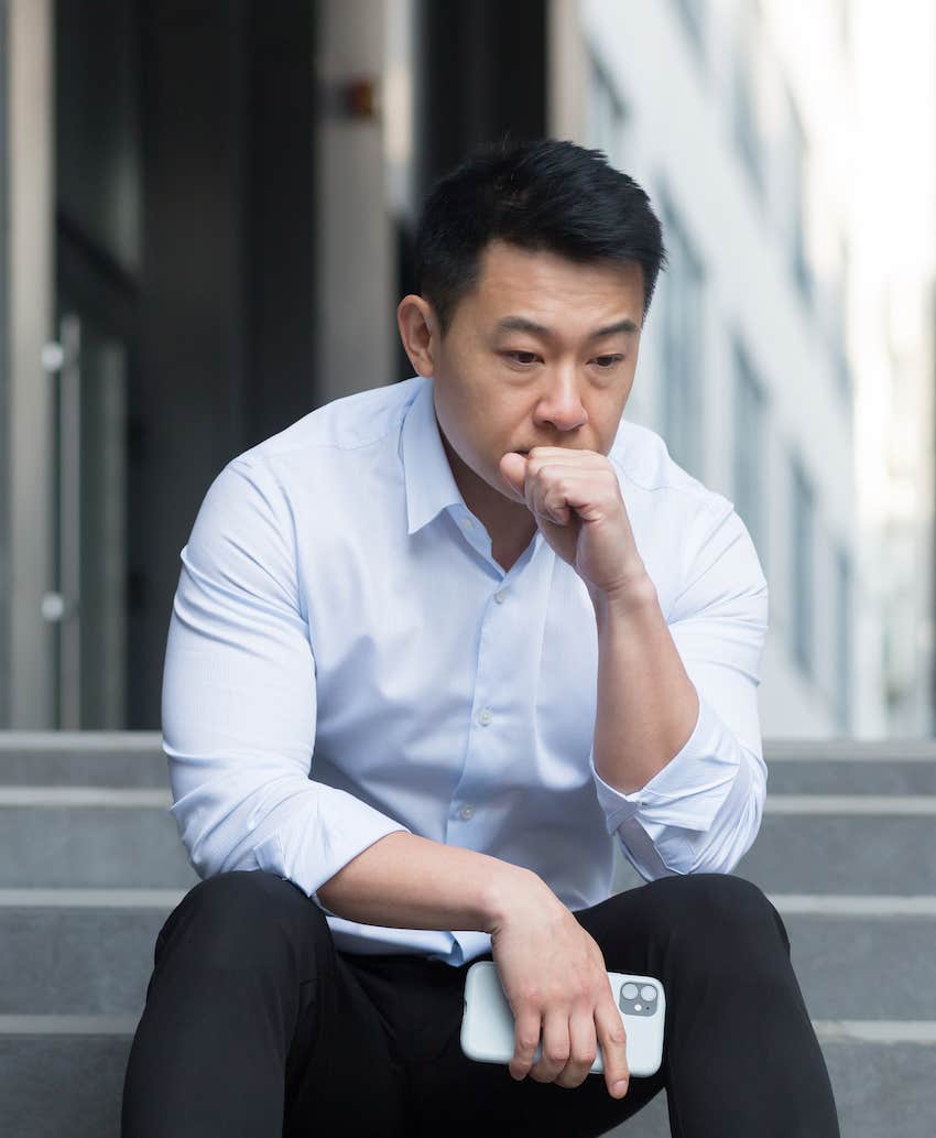 Man on stairs thinks deeply about having an affair