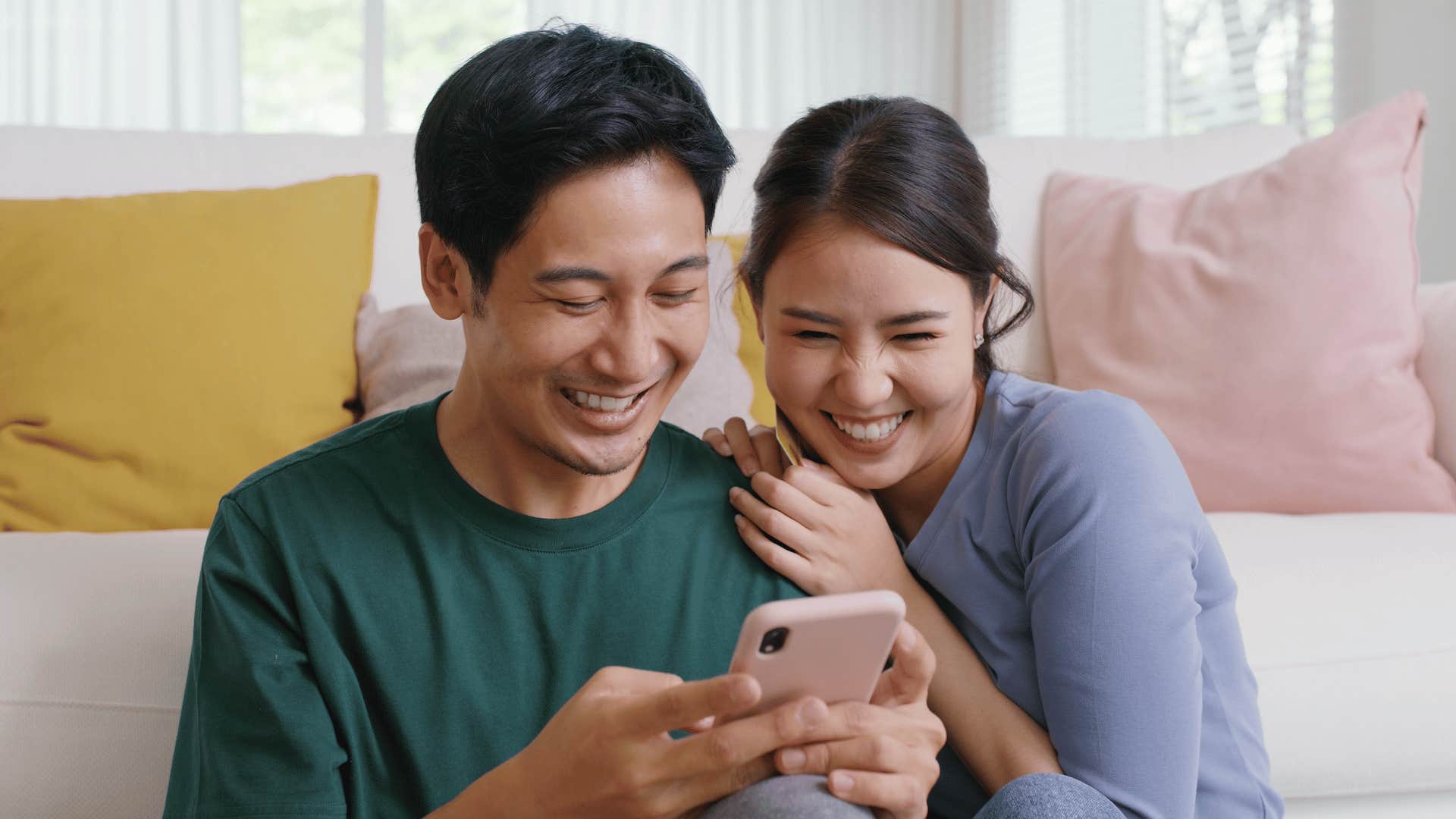 Happy couple looking at photos on a mobile device