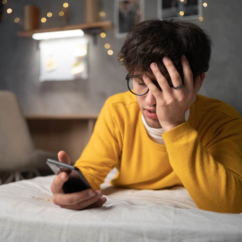 man stressed while looking at phone