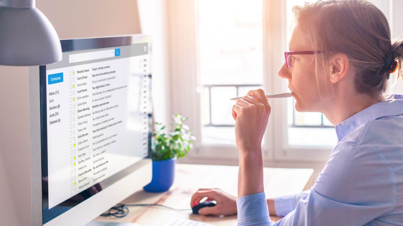 businesswoman reading email on computer screen at work