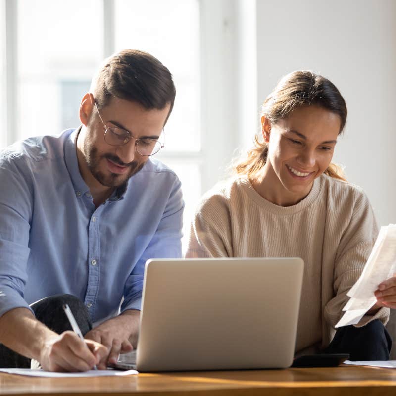 couple calculating bills in front of laptop