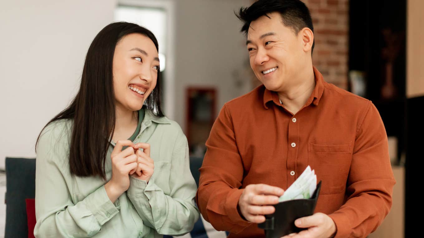 man giving money to woman from his wallet