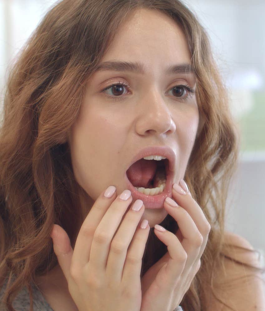 woman checking out her teeth in the mirror